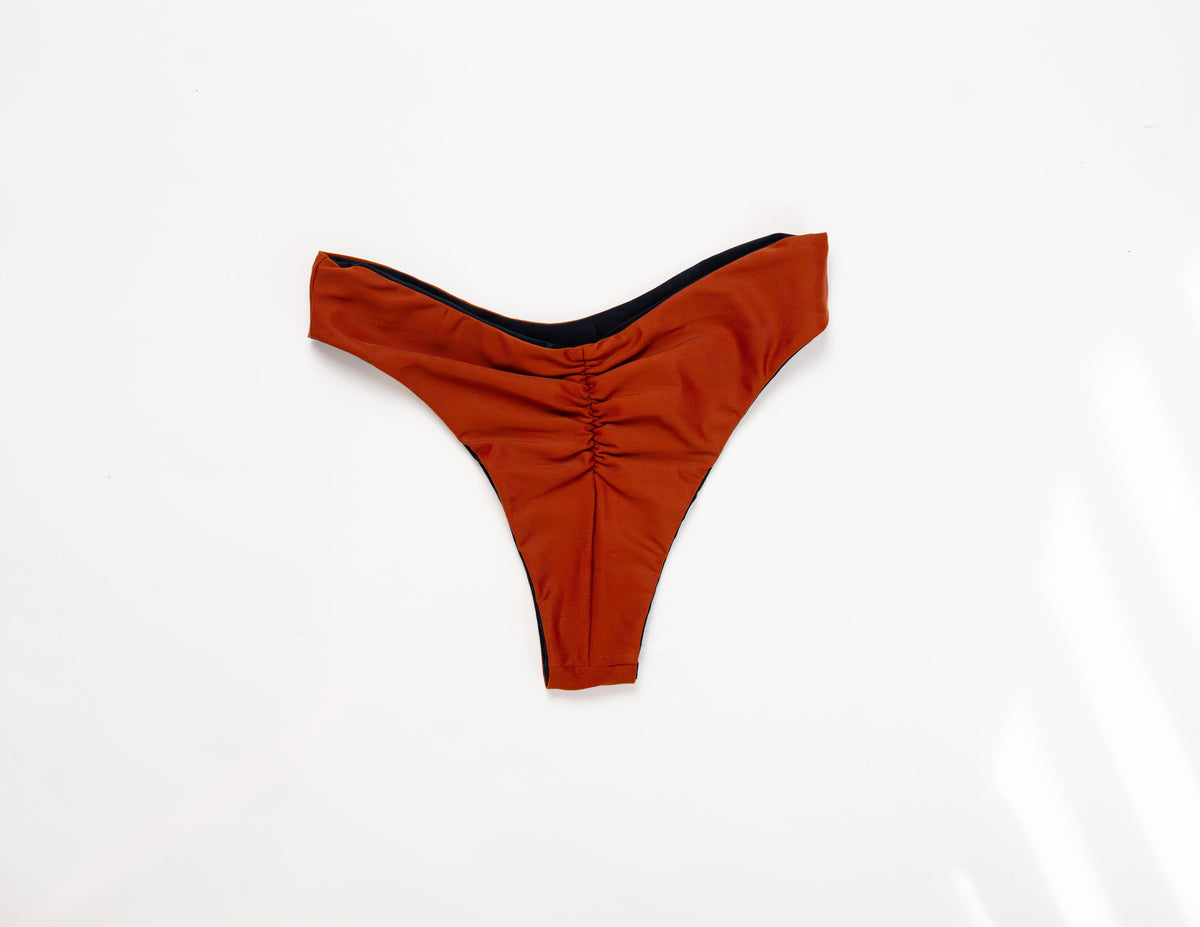 Flat lay of the Duo reversible bikini bottom in Sand showing the ruched back