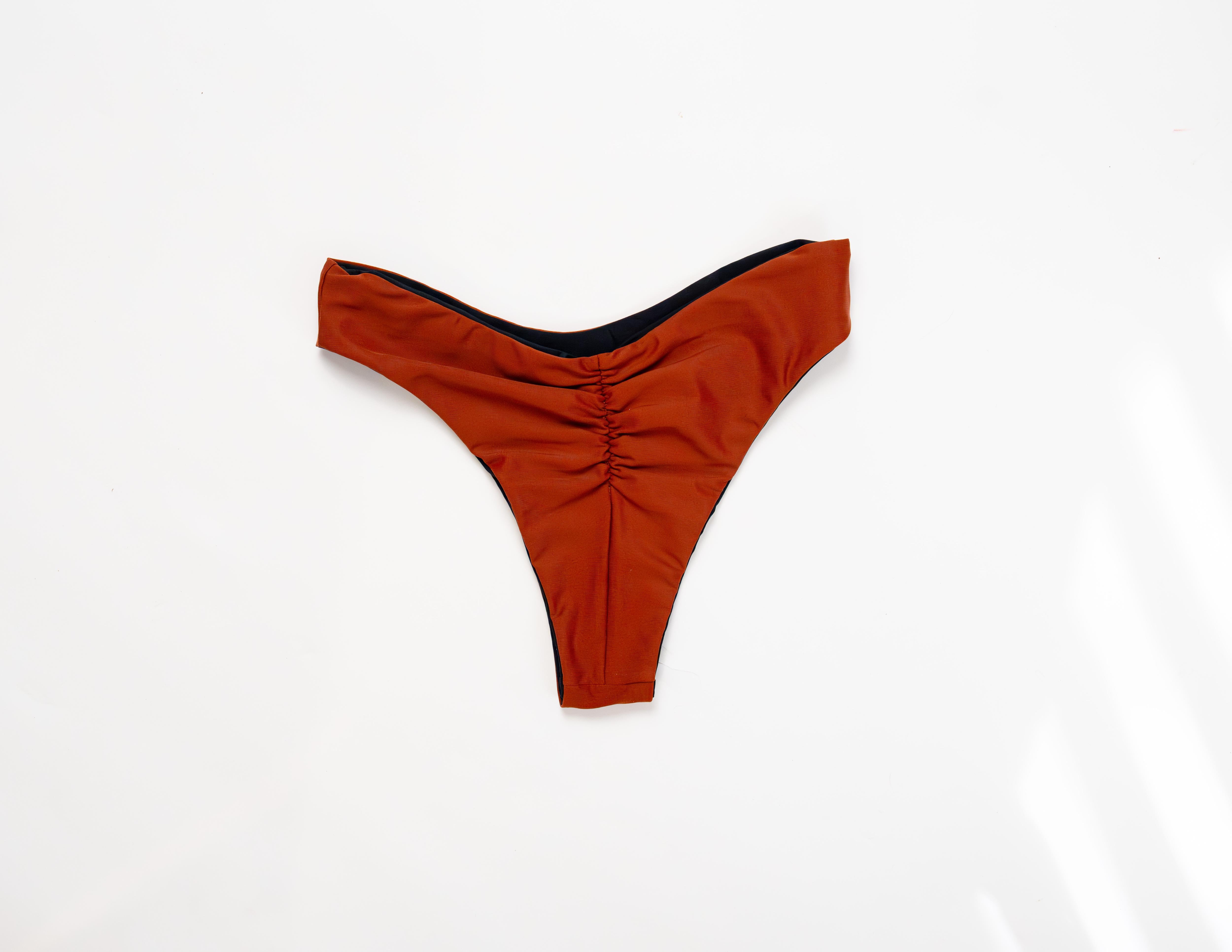 Flat lay of the Duo reversible bikini bottom in Sand showing the ruched back