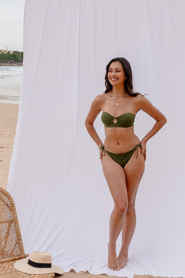 Full-length view of the Mila bandeau bikini set in forest green at the beach
